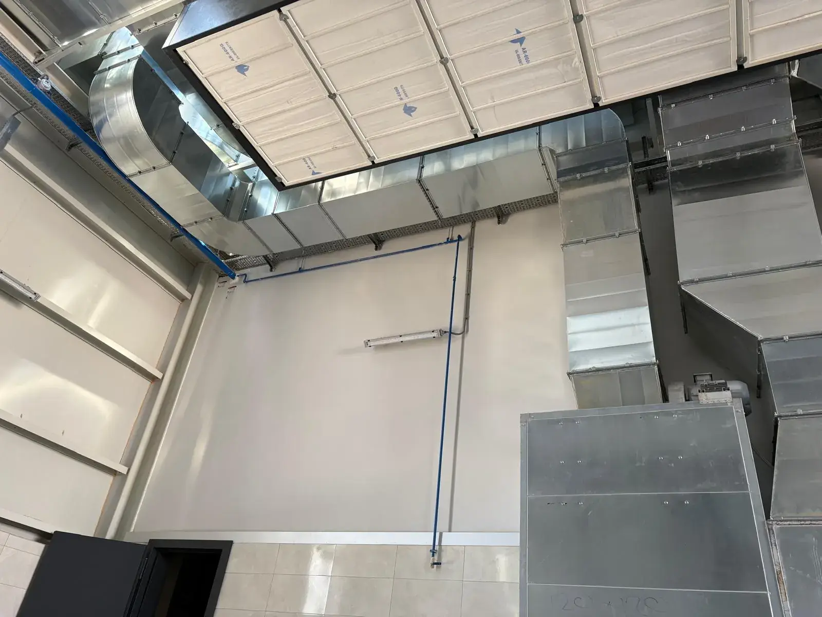 Fabrika iç mekânında tavana monte edilen galvaniz hava kanalı ve dirsek hattı