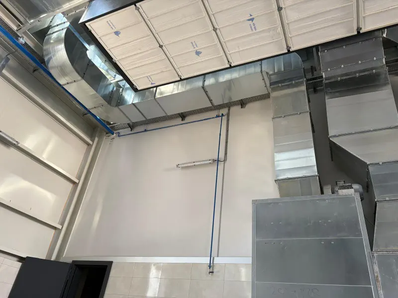 Fabrika iç mekânında tavana monte edilen galvaniz hava kanalı ve dirsek hattı