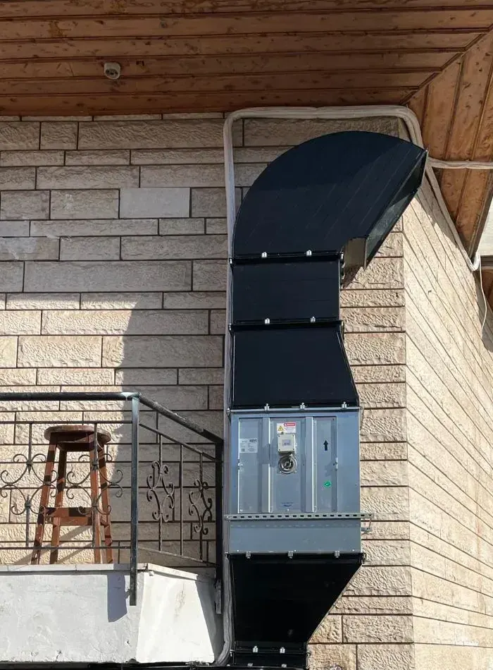 Restoran dış cephesine monte edilmiş siyah izolasyonlu mutfak davlumbaz egzoz bacası ve fan hız kontrol panosu