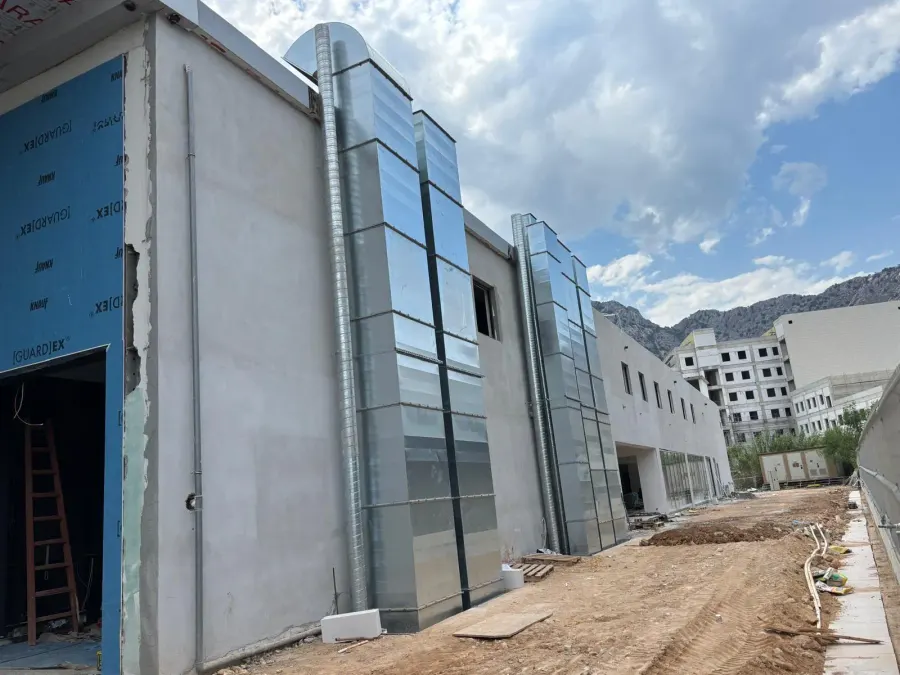 Şantiyede bina cephesine yükselen galvaniz otopark egzoz şaftı kanalları