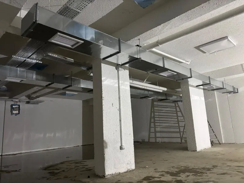 Kapalı otoparkta tavana asılmış galvaniz havalandırma kanalı hattı ve menfezleri